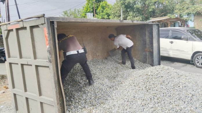 Personil Sat Lantas saat bantu bersihkan batu kerikil muatan truk cold diesel yang terbalik