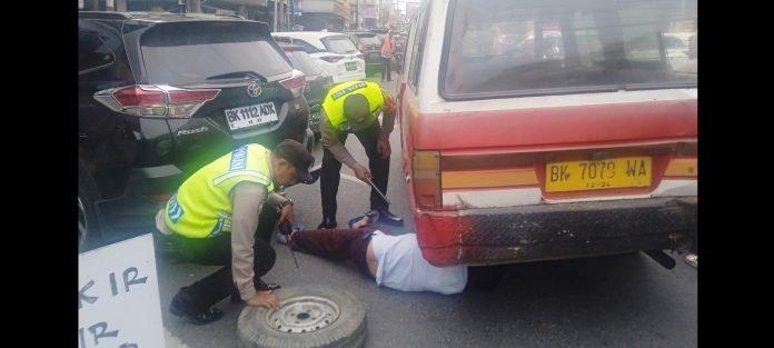 Bhabinkamtibmas Polsek Siantar Barat, AIPTU Dedy Syam SH dan AIPDA Rayendra P. Damanik  saat bantu warga bocor ban mopen