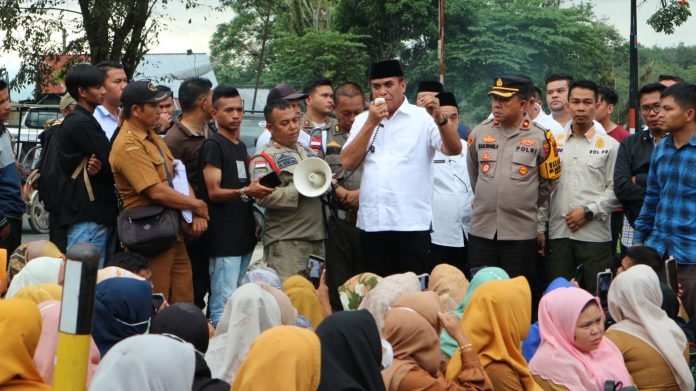 Bupati Madina, HM Jafar Sukhairi Nasution saat menjumpai tenaga guru honor yang unjuk rasa ke rumah dinas bupati di Desa Parbangunan, Rabu (27/12). (Waspada/Sarmin Harahap)