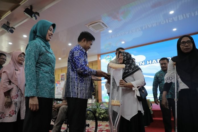 Pj. Gubernur Sumut Hassanudin bersama Pj Ketua TP PKK Sumut Dessy Hassanudin memberikan bantuan antara lain tongkat kruk kepada penyandang disabilitas.