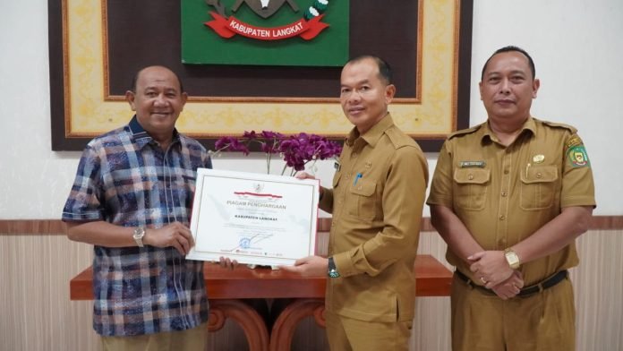 Teks Foto/Beritasore/ist  Plt Bupati Langkat H.Syah Afandin menerima penghargaan Kabupaten/kota Peduli HAM Provinsi Sumatera Utara , kemarin. 