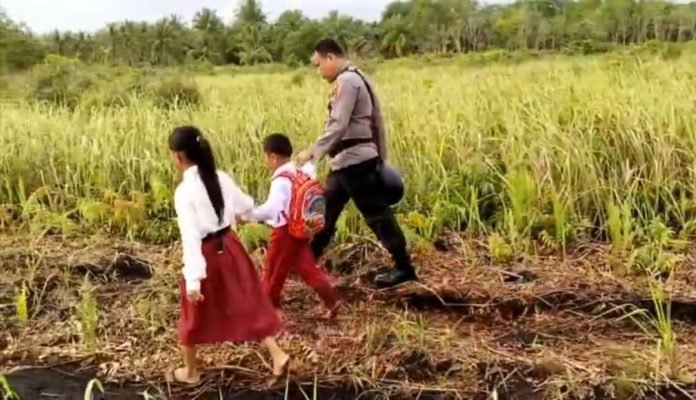 Personel Polsek Rangsang Bantu Antarkan Anak-anak Pulau Terluar Pergi ke Sekolah