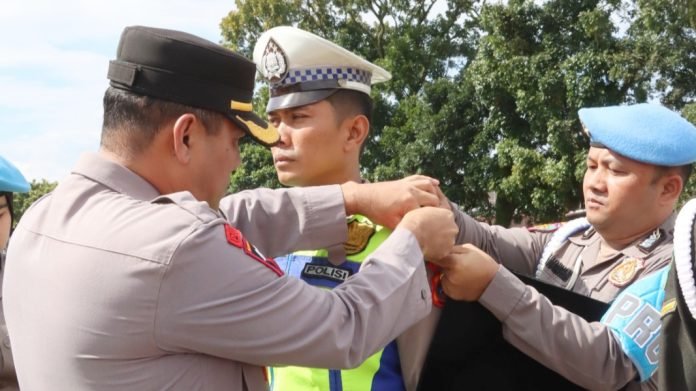 Wakapolres Siantar Kompol Pardamean Hutahaean SH, SIK, MH menyematkan tanda pida Ops Lilin Toba 2023 kepada perwakilan personil