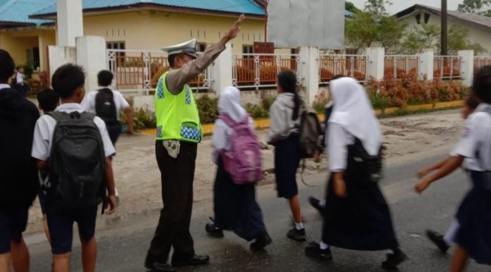 Polsek Tanah Jawa Jaga Kelancaran Lalin dan Sampaikan Pesan Kamtibmas di Depan SMP N 2 Tanah Jawa